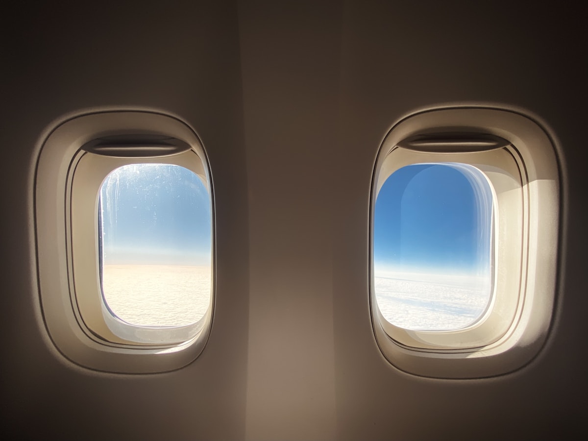 Bright airplane cabin windows above the clouds